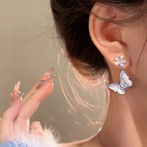 Detailed view of ice-blue butterfly drop earrings with shimmering crystal accents