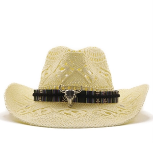 Detail of hollow woven straw cowboy hat featuring ethnic ribbon and silver bull skull charm