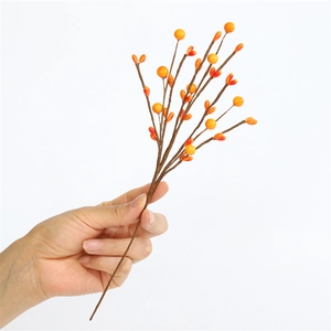 Detailed view of artificial orange berry branches with gradient yellow fruit and brown stems