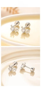 Detailed macro view of silver titanium steel kitten screw earrings with cubic zirconia