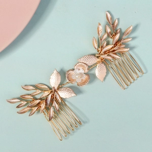 Close-up of rose gold bridal hair comb with elegant metal leaves and pearl flower detail