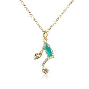 Macro shot of gold-plated snake pendant with turquoise enamel and sparkling zircons