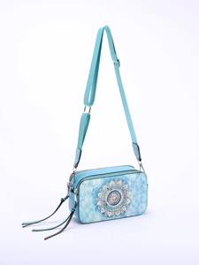 Detail of blue crossbody bag featuring intricate silver mandala patterns and adjustable strap