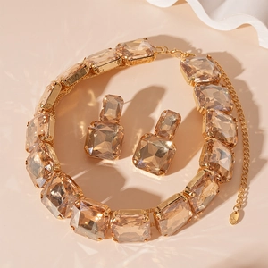 Macro shot of square-cut champagne crystals and golden settings on the jewelry set