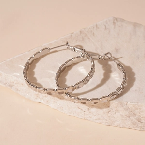 Minimalist silver oval chain hoop earrings with a textured geometric link design