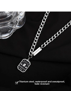 Macro detail of titanium steel Cuban chain with black rectangular good luck pendant