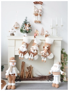 Calze di Natale in maglia beige e bambole di peluche in un elegante set per il camino