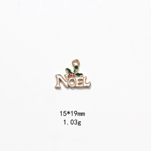 Detail view of Noel Christmas pendant showing 15x19mm size and holly enamel design