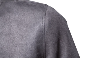 Détail macro de la couture d'épaule renforcée sur la veste en daim gris foncé