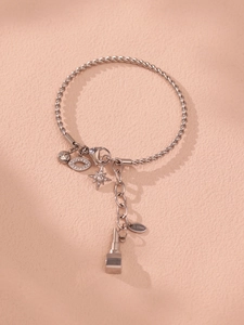 Detailansicht eines Edelstahl-Armbands mit Sternen, Lippen und Strass-Anhängern