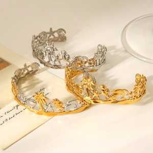 Detailed engraving of palm trees and sea life on gold and silver stainless steel bangles