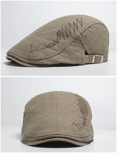 Detailed side view of khaki cotton beret showing embroidery and metal adjustment buckle