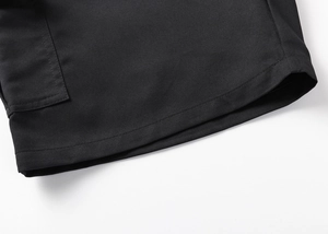 Close-up of black cargo shorts featuring durable twill fabric and double-stitch hem detail