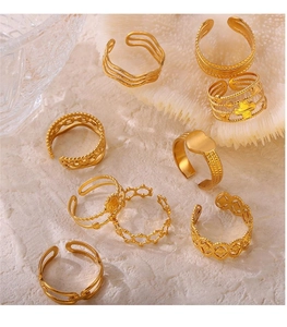 Detailed view of hollow geometric gold rings set with heart and wavy textured patterns