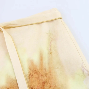 Détail de la taille avec imprimés abstraits marron sur une jupe midi de couleur beige