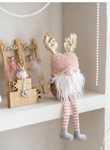 Pink Christmas gnome plush with gold reindeer antlers and striped long legs for holiday decor