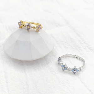 Floral clover rings with purple and blue stones on gold and silver minimalist bands