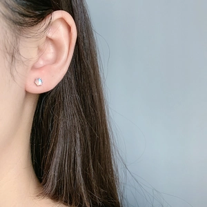 Close-up of model wearing an iridescent moonstone stud earring with screw back