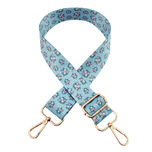 Blue floral print fabric bag strap with gold metal buckle and swivel hooks on white base