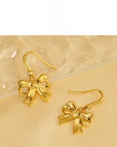 Macro detail of 18K gold plated bow earrings featuring sparkling micro-inlaid zircons