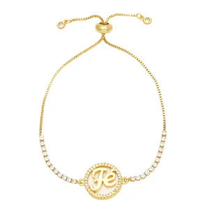 Adjustable gold cross bracelet with sparkling zircon stones and Fe pendant on white background