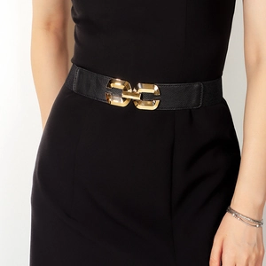 Close-up of women's elastic waist belt featuring a gold geometric interlocking buckle
