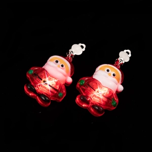 Detail shot of LED glowing Santa Claus earrings with red and white lights on black backdrop