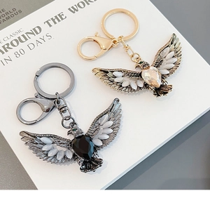Detailed view of eagle keychains in gold and gunblack finishes with cat-eye stones