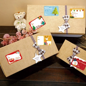 Christmas gift seal stickers featuring reindeer and snowmen on kraft paper gift box
