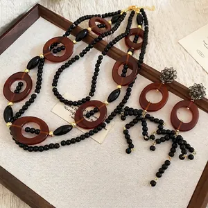 Ethnic crystal oval fringe necklace and earring set in black and amber resin finish