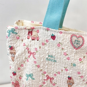 Close-up of cute dog and floral print on white canvas bag with turquoise webbing strap