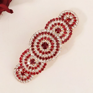Elegant red crystal hair clip with rhinestone design on a sleek metal base