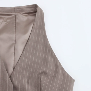 Detailed close-up of taupe pinstripe vest showing V-neckline and premium fabric texture