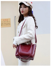 Detail of dark red faux leather tote bag showing smooth texture and adjustable strap