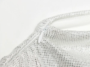 Gros plan d'une robe en résille argentée à strass avec une fermeture éclair invisible