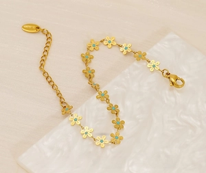 Detail of gold stainless steel daisy chain bracelet with turquoise stone flower centers