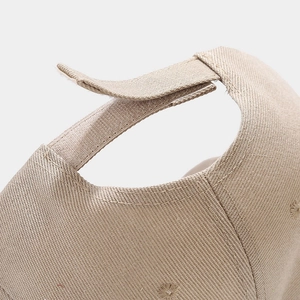 Detail of adjustable hook-and-loop strap on beige cotton twill baseball cap back