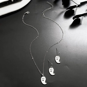 Close-up of white enamel ghost pendant and matching earrings with silver chain