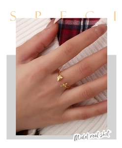 Detailed close-up of a golden butterfly and bee open ring worn on a model's hand