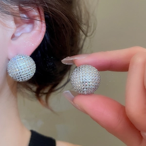 Macro shot of large round silver studs encrusted with sparkling cubic zirconia crystals
