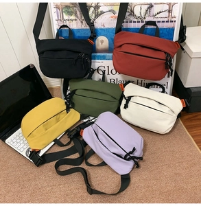 Detailed flat lay of six colorful minimalist nylon crossbody bags in a lifestyle setting
