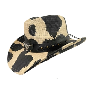 Detail of western cow print straw hat with black leather band and silver bull head stud
