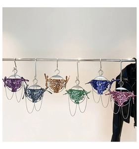 Detail view of mini leopard print bikini bags in six colors hanging on a metal rack