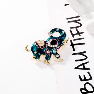 Detailed view of an elephant brooch with green enamel, gold plating, and rhinestones