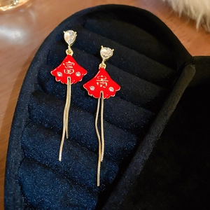 Detailed macro view of Chinese New Year earrings with red fan and golden tassels