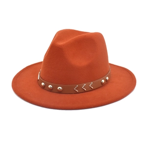 Detail of orange fedora hat with brown leather band, silver studs and V-shaped stitching