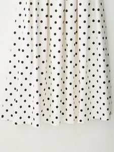 Détail du drapé du tissu et des pois noirs sur la jupe blanche élégante