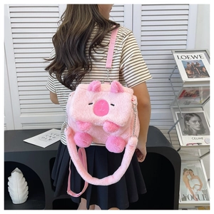 Detailed back view of a pink plush cartoon pig backpack with adjustable straps on a model
