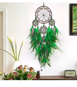 Detail of green and brown handmade dream catcher with feathers and wood beads on wall