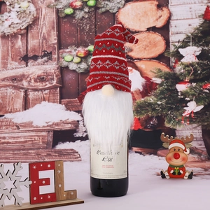 Christmas gnome wine bottle cover with red knit hat and white beard on festive background